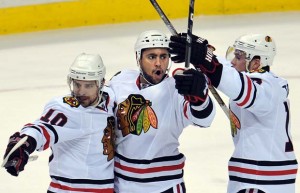 Dustin Byfuglien celebrates his 1st goal with Patrick Sharp and Jonathan Toews