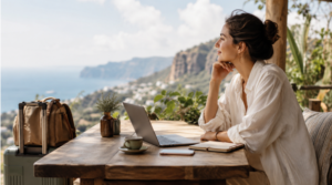 woman working by the sea and mountains with a laptop